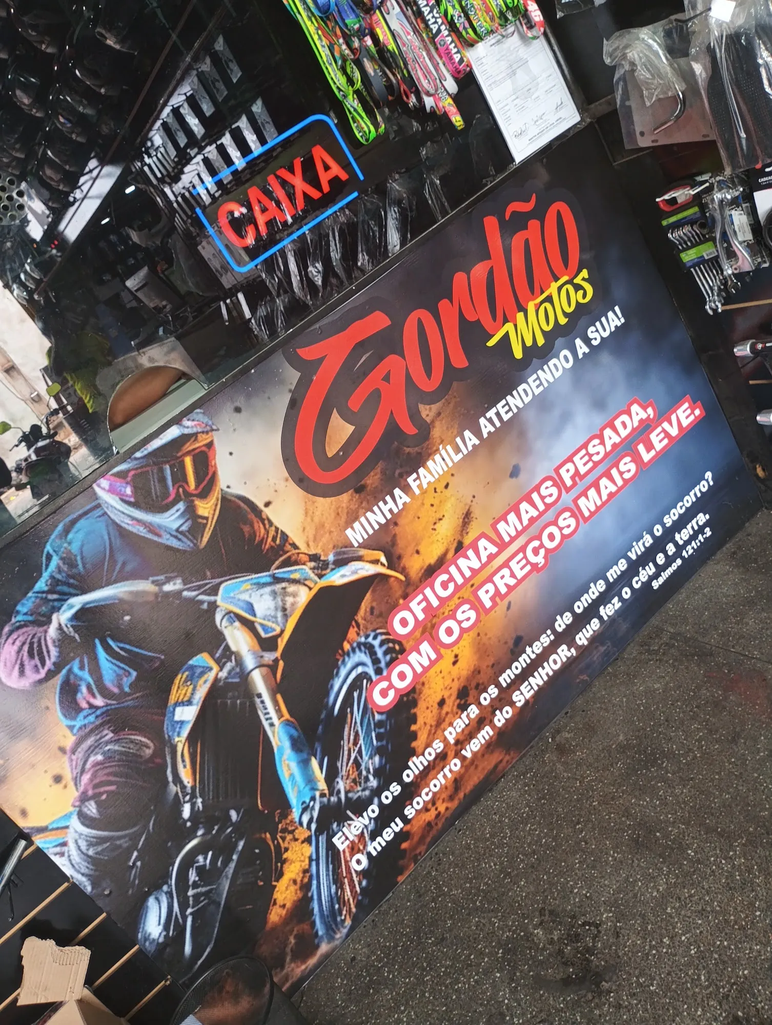 Banner do balcão com o logo Gordão Motos e o slogan "a oficina mais pesada, com os preços mais leves"