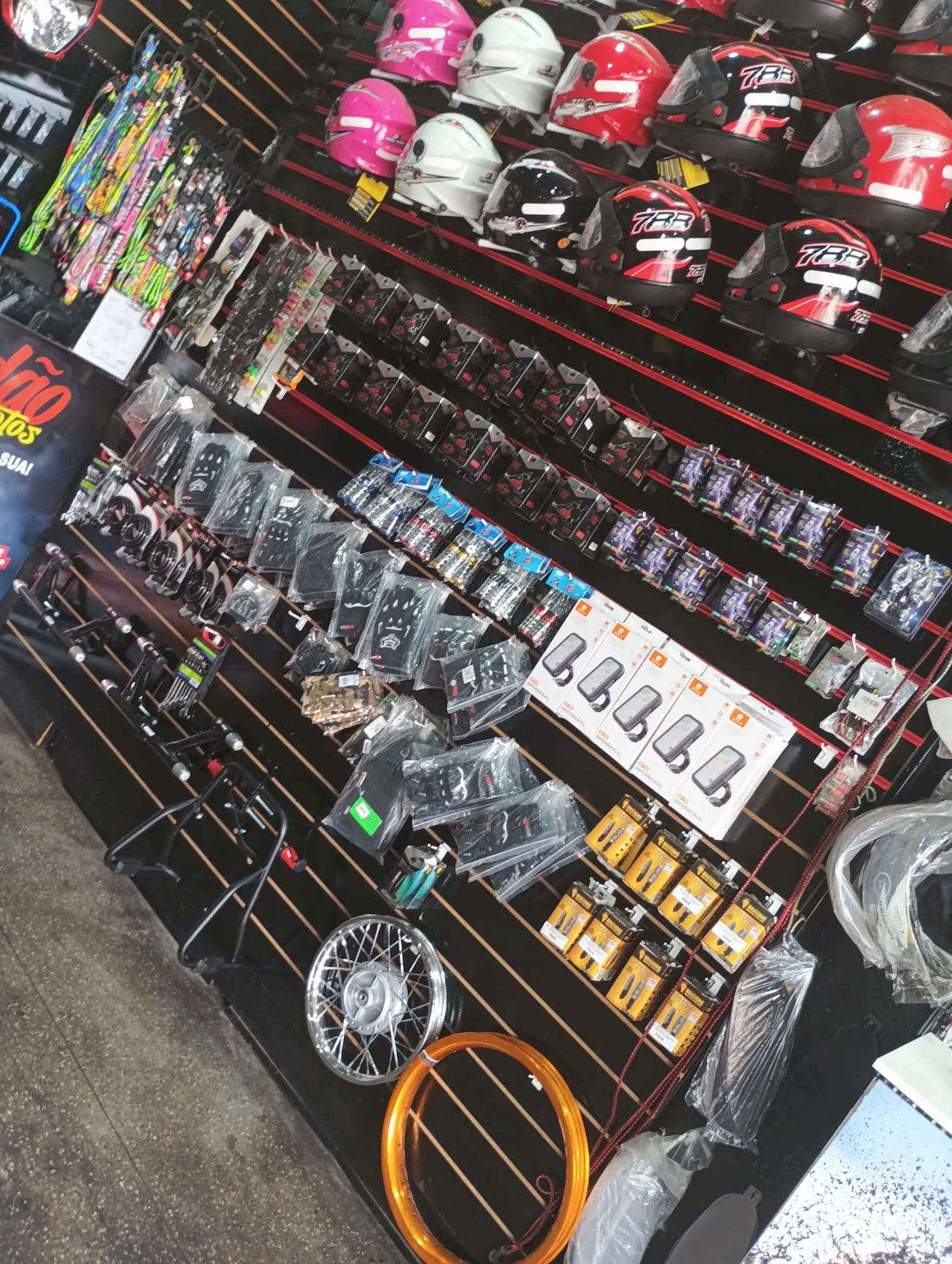 Expositor com capacetes, luvas, manetes, cavaletes e aros de roda à venda